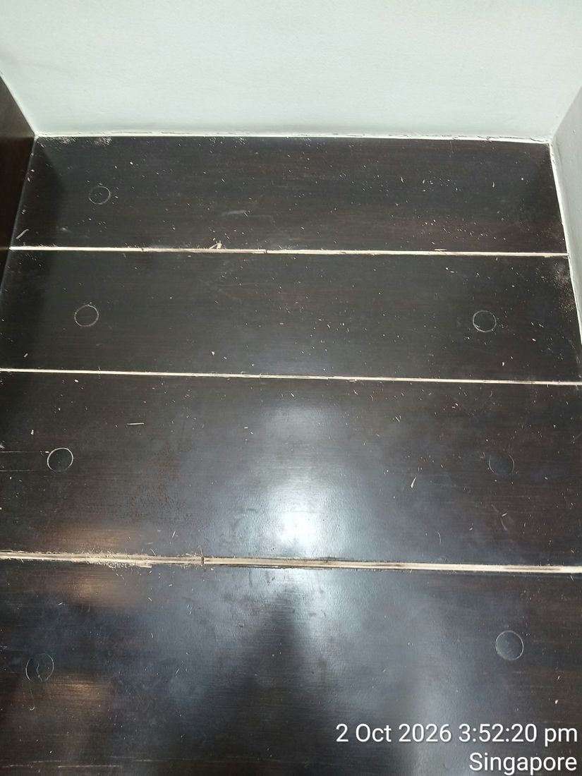 Dark-stained timber stair boards with open gaps before repair