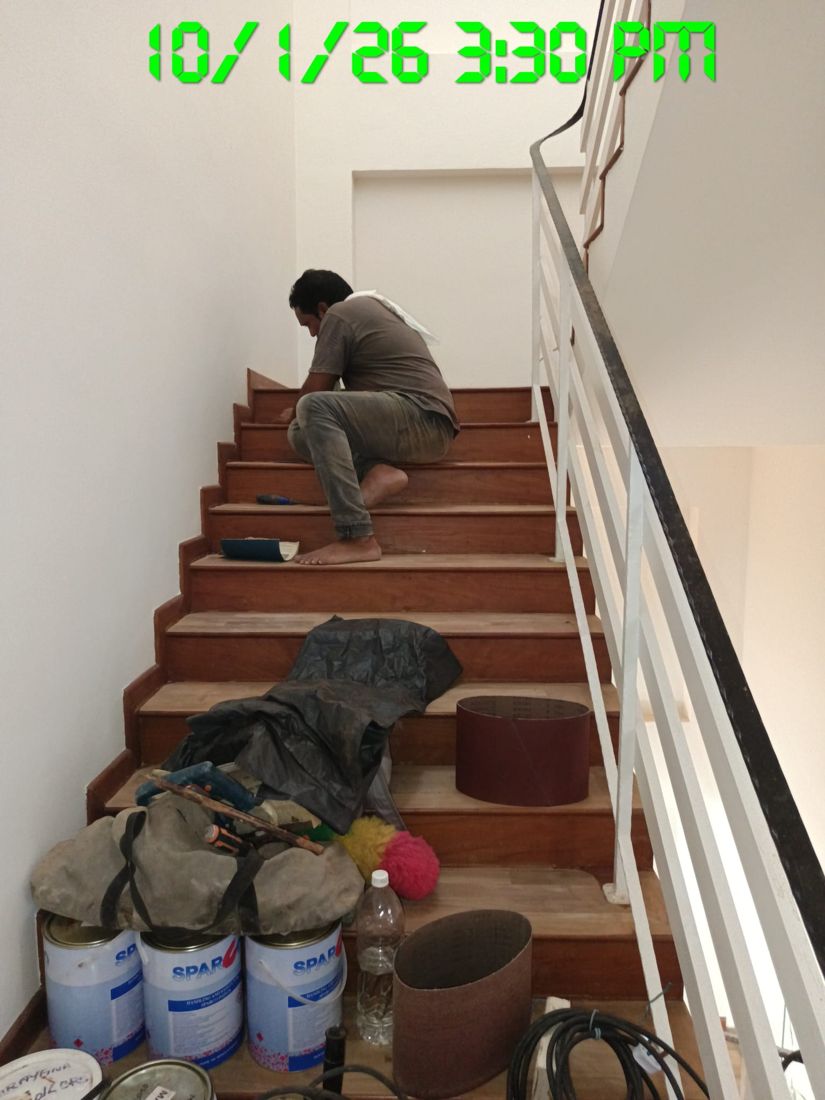 Technician hand-sanding timber stair treads and nosings